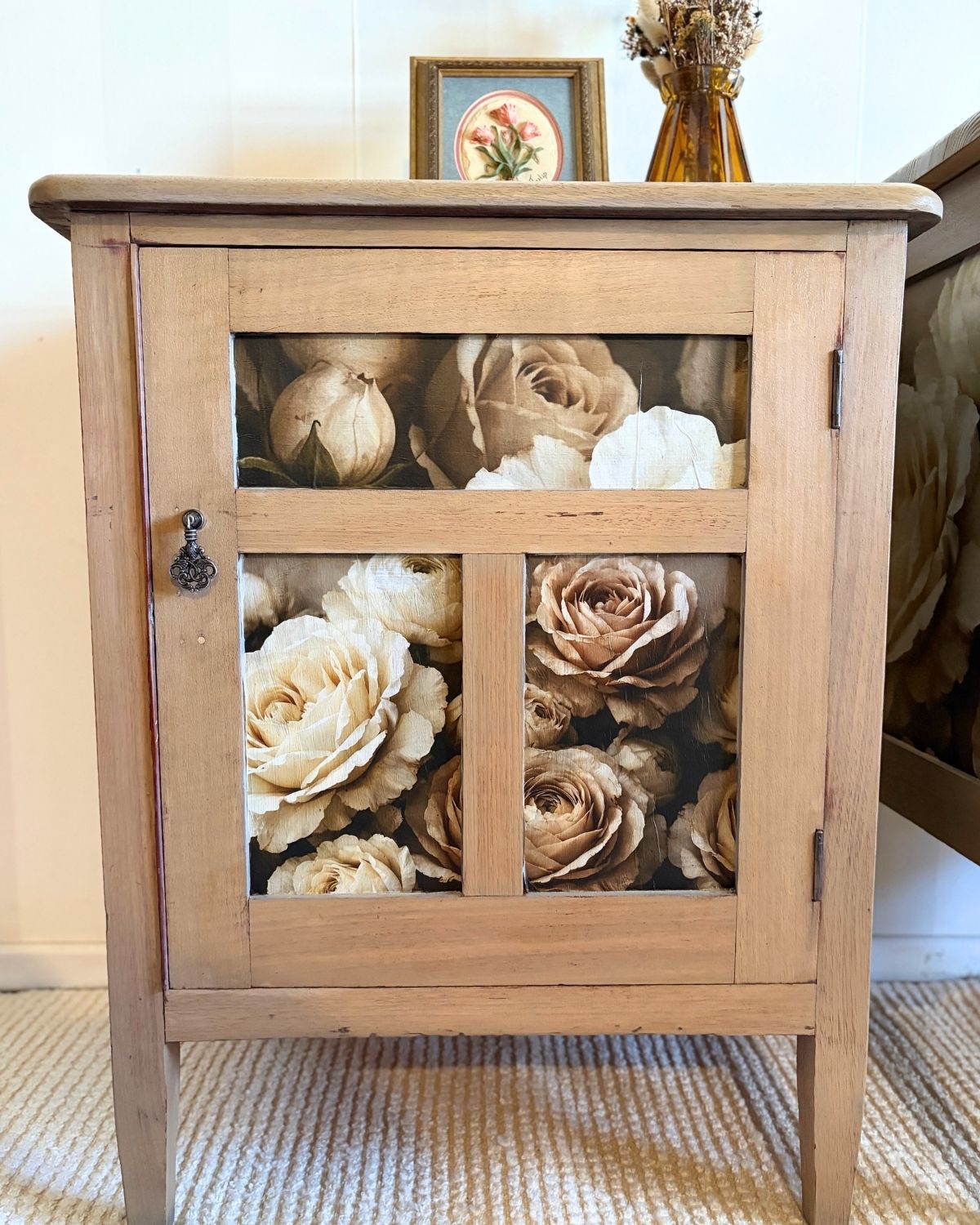 Lower antique hardwood bedside table with floral panels and a vintage-look drop handle