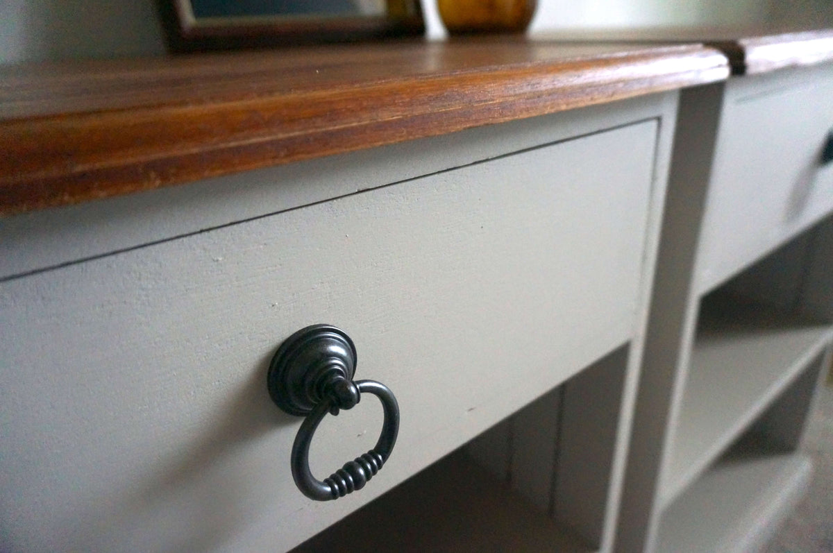 A close-up of a painted jarrah bedside table with a Velvet Taupe drawer front, dark metal ring pull, and a medium brown wood top.
