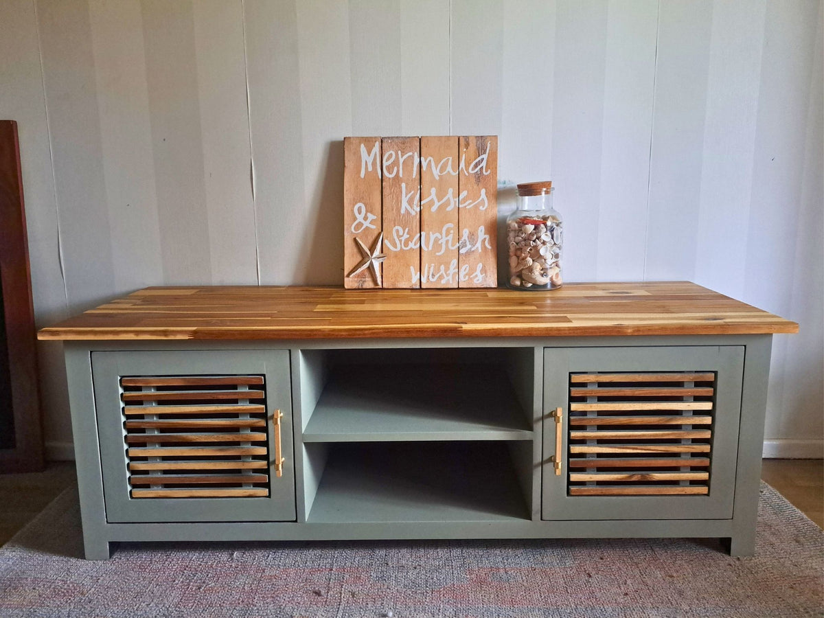 Sage green coastal TV unit with natural timber details and wooden hardware